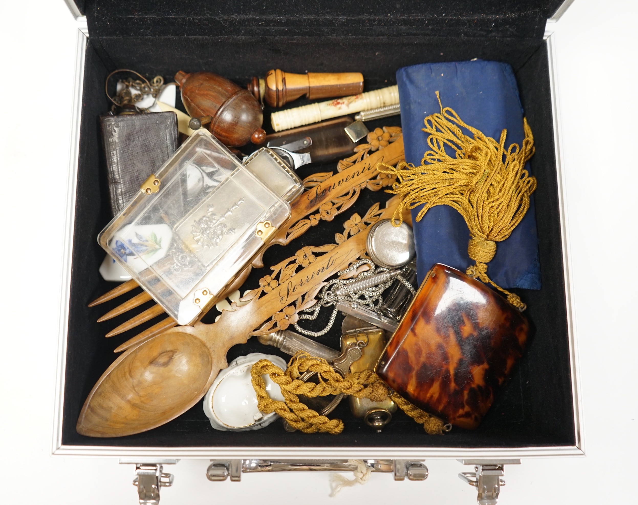 A metal case containing mixed collectibles including treen whistles, a cigarette case, three white metal propelling pencils etc